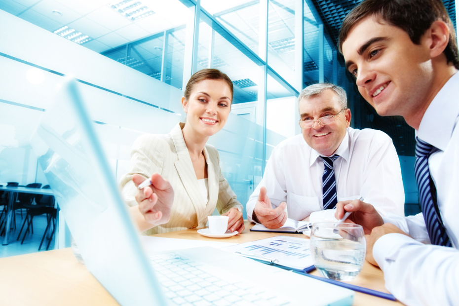 A business team of three sitting in office and planning work